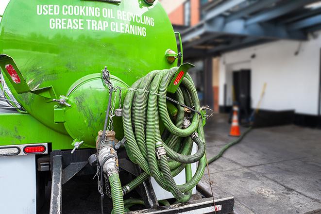 a grease trap being pumped by a sanitation technician in Keego Harbor, MI